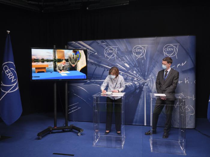 Nigel Lockyer, Director of Fermilab (left, on the screen) and Fabiola Gianotti, CERN Director-General, sign a Memorandum of Understanding in the presence of Mike Lamont, CERN Director for Accelerators and Technology (Image: CERN)